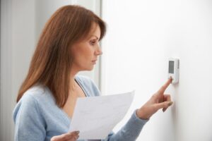 Woman Adjusting HVAC Thermostat